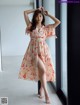 A woman standing in front of a window wearing a dress.