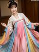 A young girl wearing a colorful hanbok is posing for a picture.