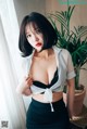 A woman in a white shirt and black skirt posing for a picture.