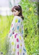 A woman in a white dress standing in a field of tall grass.