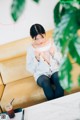 A woman sitting on a couch with a cup of coffee.