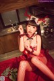 A woman in a red dress sitting on a kitchen counter.